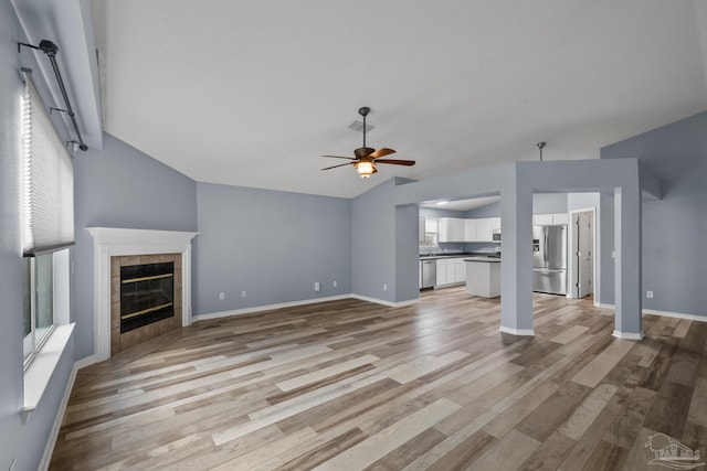 unfurnished living room with a fireplace, light wood-type flooring, and ceiling fan