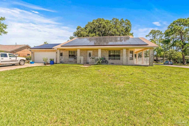 ranch-style house featuring a garage, solar panels, and a front yard