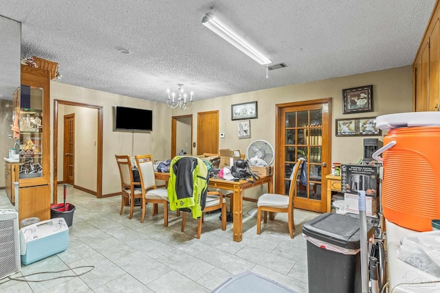 dining space featuring an inviting chandelier, a textured ceiling, and light tile patterned floors