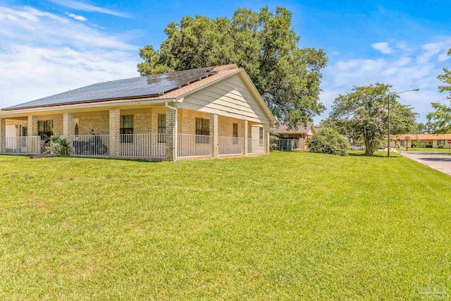 view of side of home with a yard and solar panels