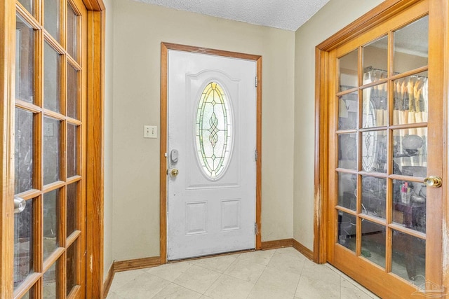 foyer entrance featuring light tile patterned flooring and a textured ceiling