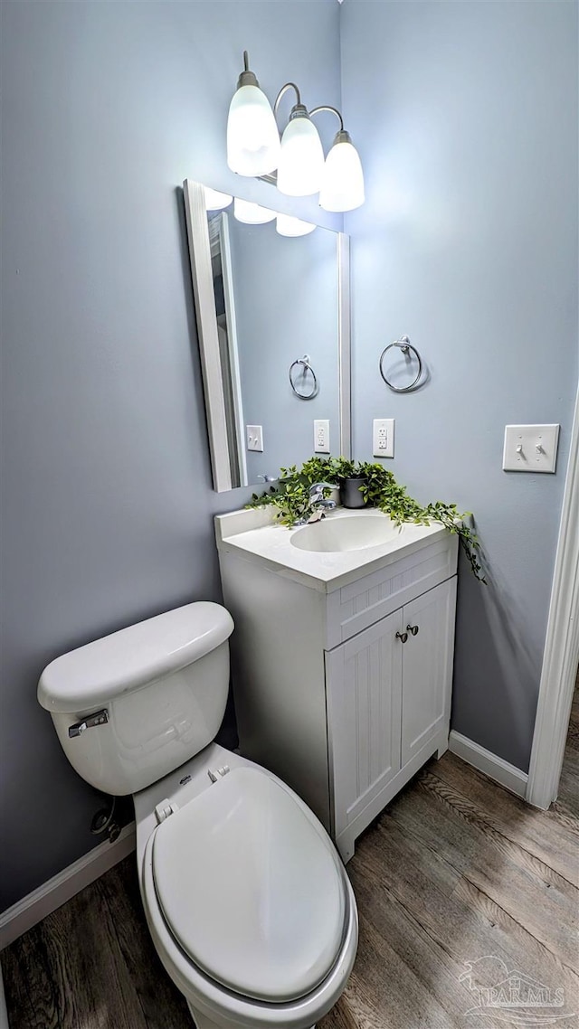 6818 Roundup Ln, Milton, FL 32570 - bathroom with wood finished floors, vanity, baseboards, and toilet
