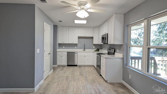 6818 Roundup Ln, Milton, FL 32570 - kitchen with appliances with stainless steel finishes, a sink, light countertops, light wood-style floors, and ceiling fan