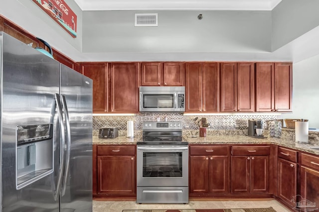 13928 River Rd Unit 904, Pensacola, FL 32507 - kitchen with visible vents, backsplash, light stone countertops, stainless steel appliances, and reddish brown cabinets