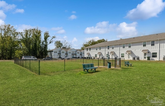 view of community featuring a residential view, fence, and a yard