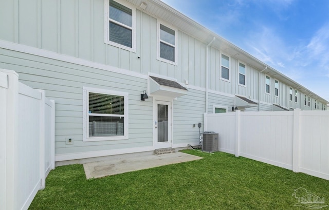 rear view of house with a lawn, fence, and board and batten siding