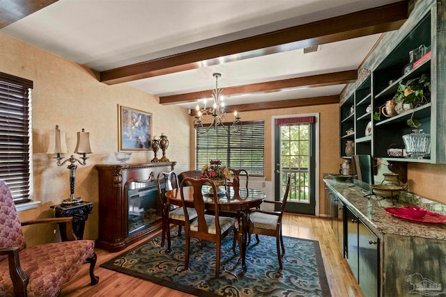 dining room with an inviting chandelier, light wood-type flooring, and beam ceiling