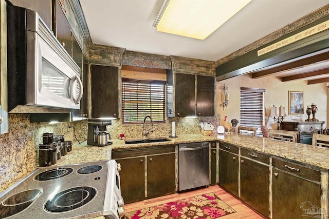 kitchen featuring dark brown cabinets, light wood-type flooring, appliances with stainless steel finishes, and sink