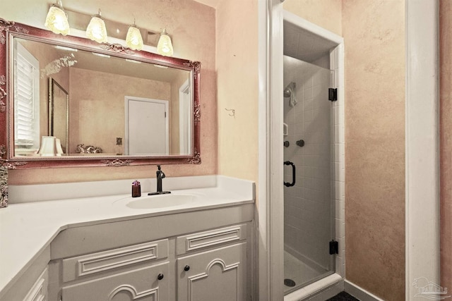 bathroom featuring a shower with door and vanity