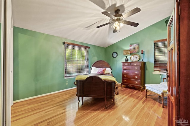 bedroom featuring light hardwood / wood-style flooring, vaulted ceiling, and ceiling fan