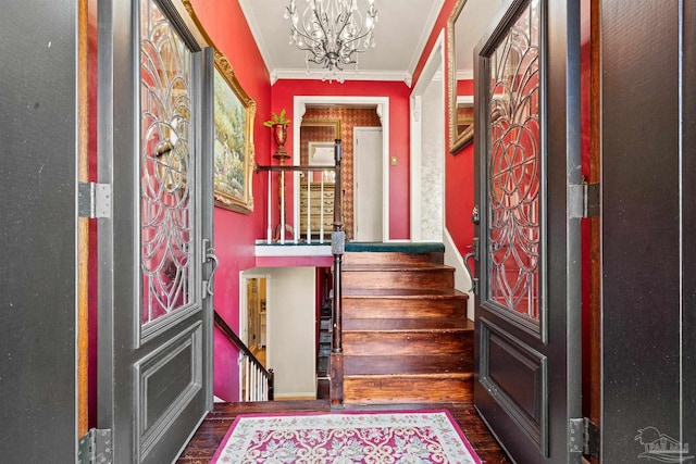 entrance foyer featuring crown molding, dark wood-type flooring, and a chandelier