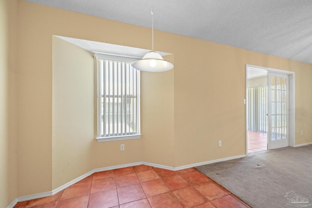 carpeted empty room featuring a textured ceiling