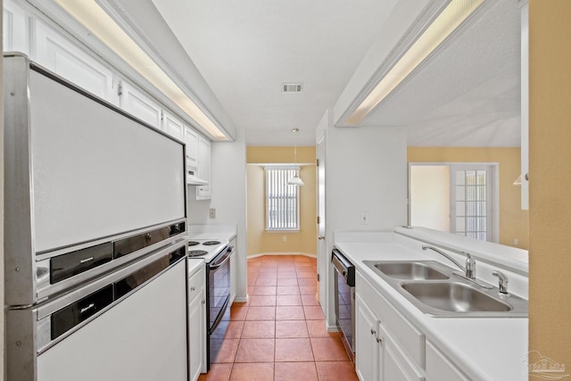 kitchen with stainless steel appliances, sink, decorative light fixtures, light tile patterned floors, and white cabinetry