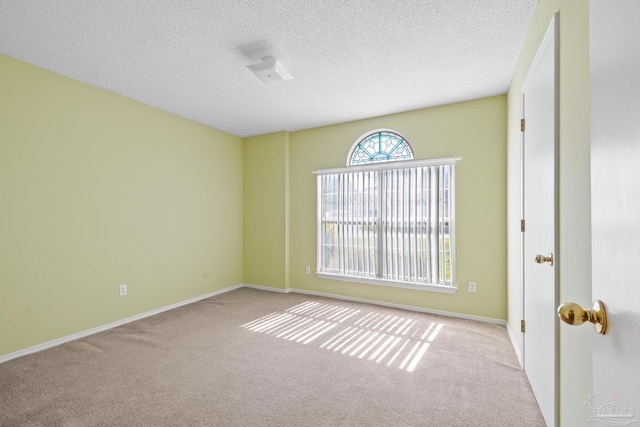 carpeted spare room featuring a textured ceiling