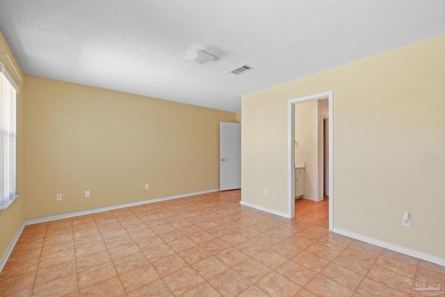 unfurnished room featuring a healthy amount of sunlight and a textured ceiling