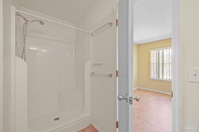 bathroom with a textured ceiling and a shower