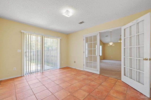 tiled empty room with french doors, ceiling fan, and a textured ceiling