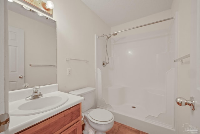 bathroom featuring a textured ceiling, a shower, toilet, vanity, and tile patterned floors