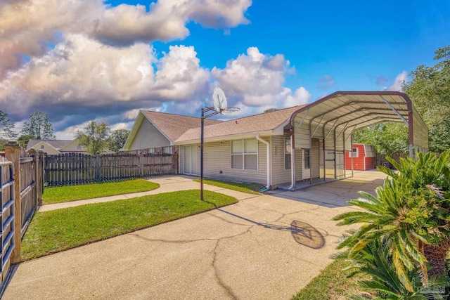 back of house featuring a lawn and a carport