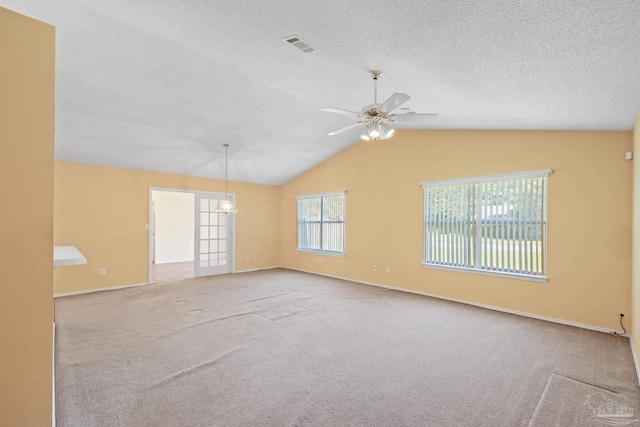 carpeted spare room with lofted ceiling, a textured ceiling, and ceiling fan