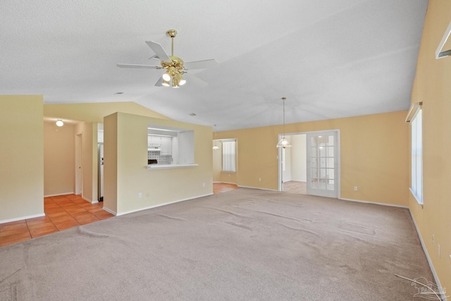 unfurnished living room featuring light carpet, lofted ceiling, a healthy amount of sunlight, and ceiling fan