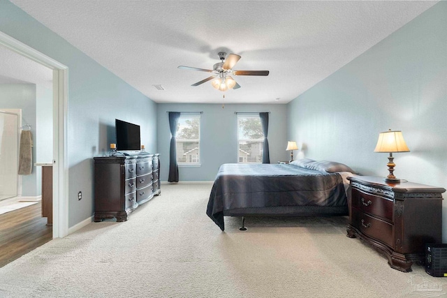 bedroom with a textured ceiling, ceiling fan, carpet flooring, and baseboards