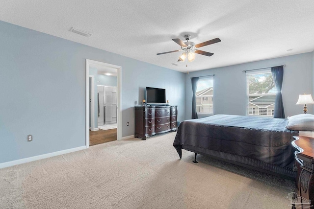 bedroom featuring visible vents, ensuite bathroom, carpet flooring, a textured ceiling, and baseboards