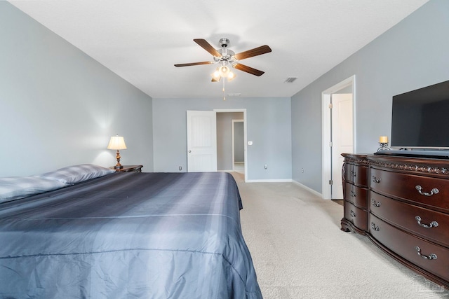 bedroom with light carpet, ceiling fan, visible vents, and baseboards