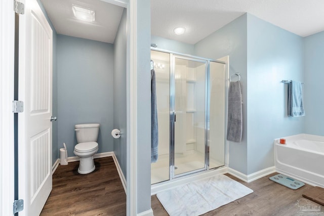 full bath featuring toilet, a shower stall, baseboards, and wood finished floors