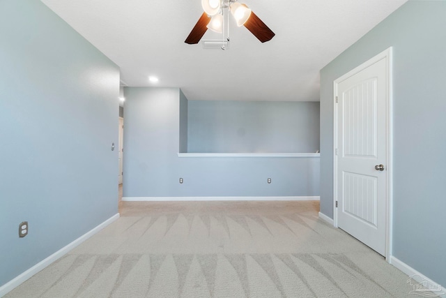 empty room with carpet, a ceiling fan, and baseboards