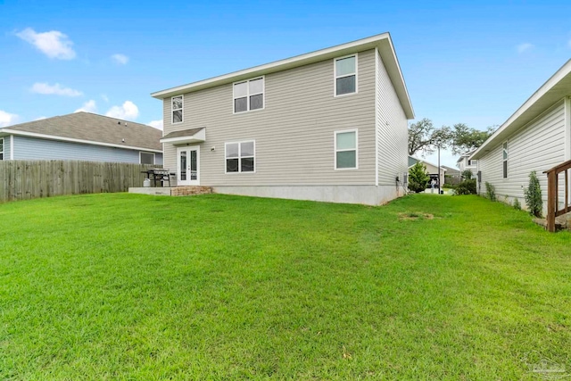 back of house featuring french doors, a patio area, a yard, and fence