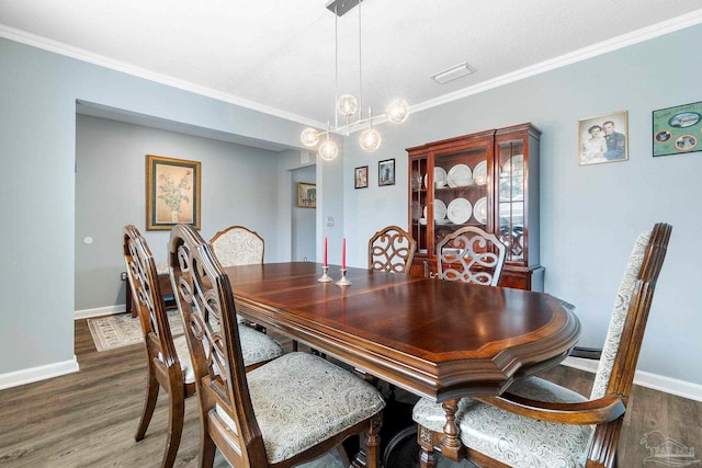 dining space with visible vents, crown molding, baseboards, and wood finished floors