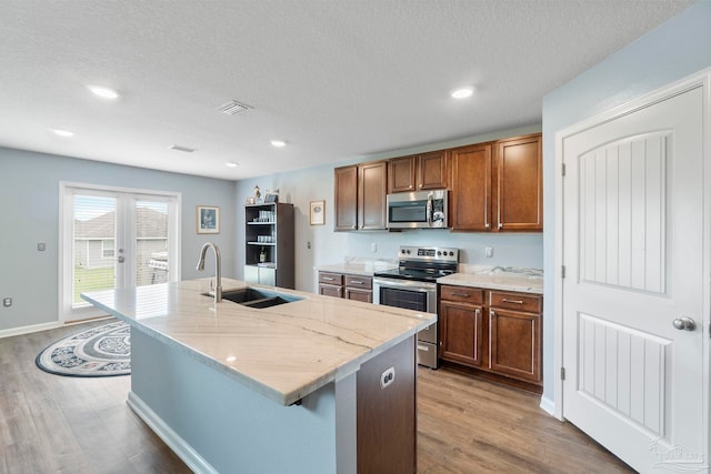 kitchen featuring a sink, visible vents, french doors, appliances with stainless steel finishes, and light wood finished floors