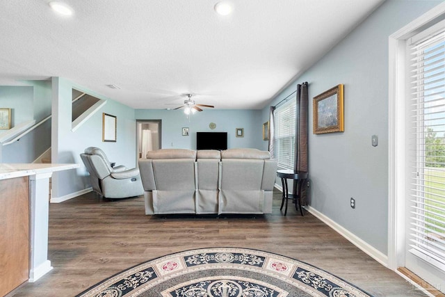 living area featuring plenty of natural light, baseboards, and dark wood finished floors