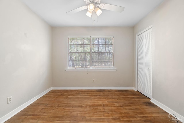 unfurnished bedroom with ceiling fan, a closet, baseboards, and wood finished floors