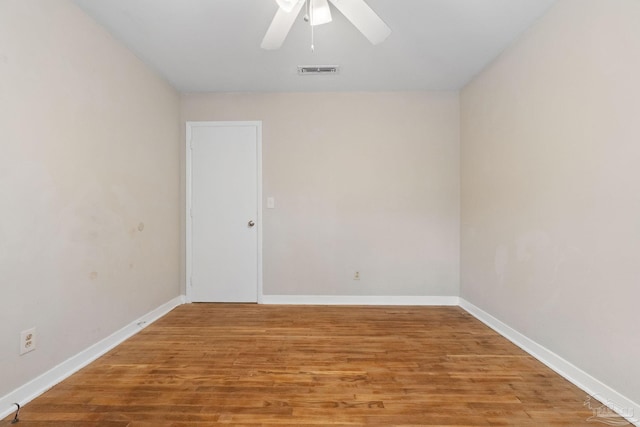 spare room featuring visible vents, baseboards, and wood finished floors