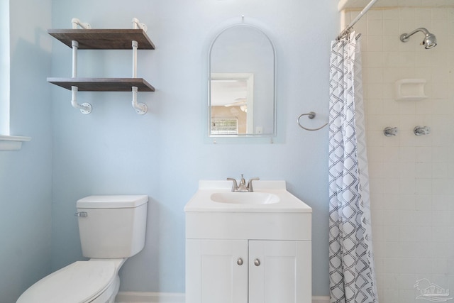 bathroom with a tile shower, toilet, and vanity