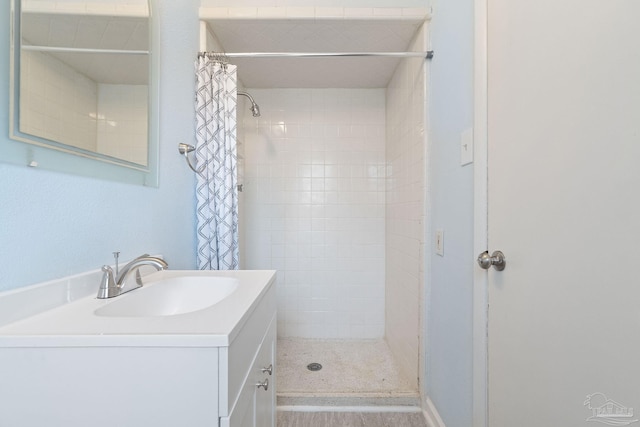 full bathroom featuring vanity and tiled shower