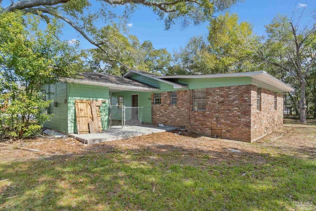 back of property featuring a yard, brick siding, and crawl space