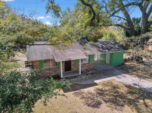 ranch-style home featuring a porch, brick siding, and roof with shingles