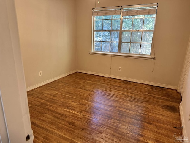 unfurnished room with baseboards and wood finished floors