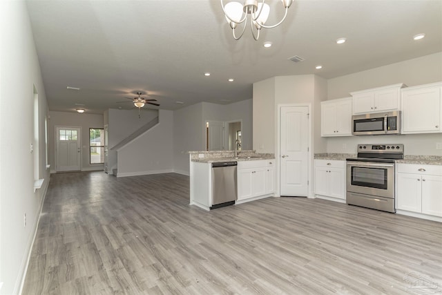 kitchen with ceiling fan with notable chandelier, stainless steel appliances, light hardwood / wood-style floors, and white cabinetry