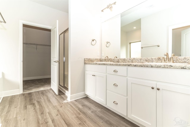 bathroom with vanity, wood-type flooring, and a shower with shower door