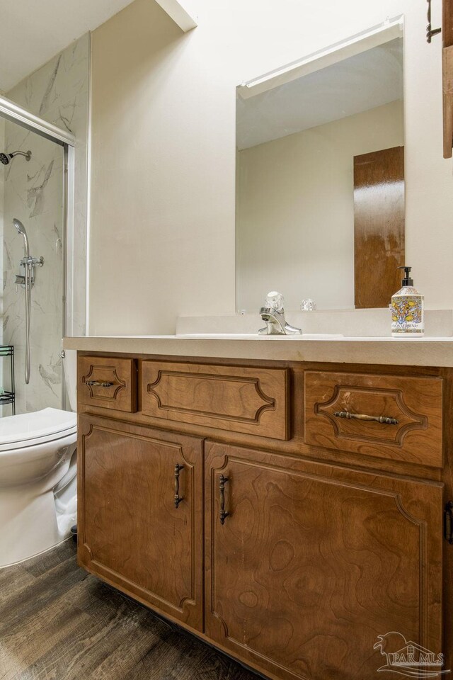 bathroom featuring vanity, toilet, wood-type flooring, and an enclosed shower