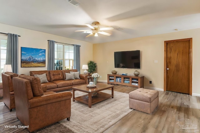 living room featuring a wealth of natural light, hardwood / wood-style flooring, and ceiling fan