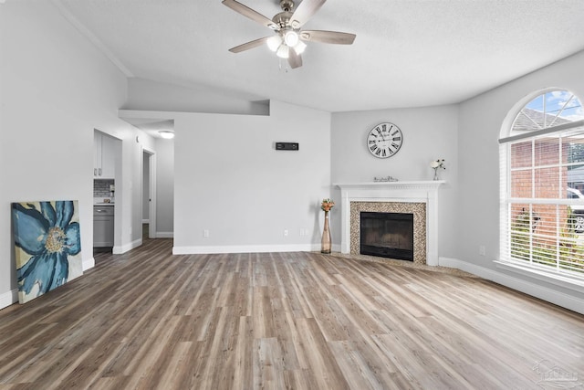 5732 Dove Dr, Pace, FL 32571 - unfurnished living room with ceiling fan, a tile fireplace, light wood-style flooring, healthy amount of natural light, and lofted ceiling