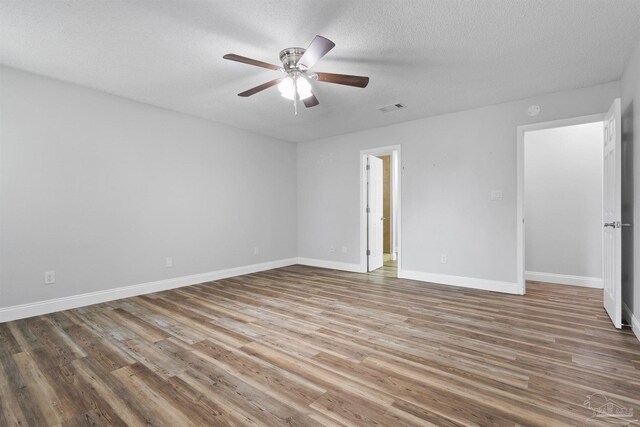 5732 Dove Dr, Pace, FL 32571 - empty room with wood finished floors, ceiling fan, baseboards, and a textured ceiling