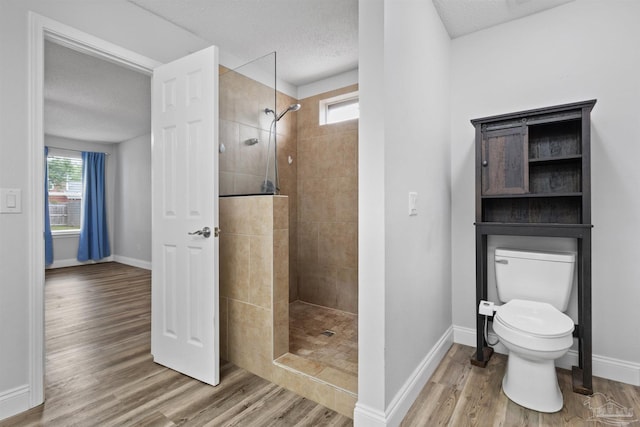 5732 Dove Dr, Pace, FL 32571 - bathroom with plenty of natural light, walk in shower, wood finished floors, baseboards, and a textured ceiling
