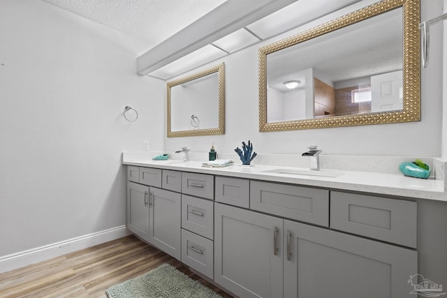 5732 Dove Dr, Pace, FL 32571 - full bathroom with a textured ceiling, double vanity, wood finished floors, and baseboards