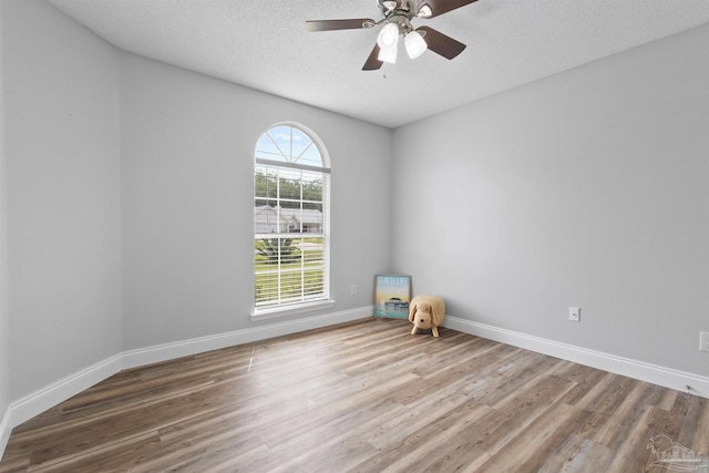 5732 Dove Dr, Pace, FL 32571 - spare room featuring wood finished floors, a textured ceiling, ceiling fan, and baseboards